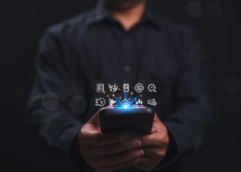 Mann hält Smartphone mit digitalen Symbolen | E Liquid