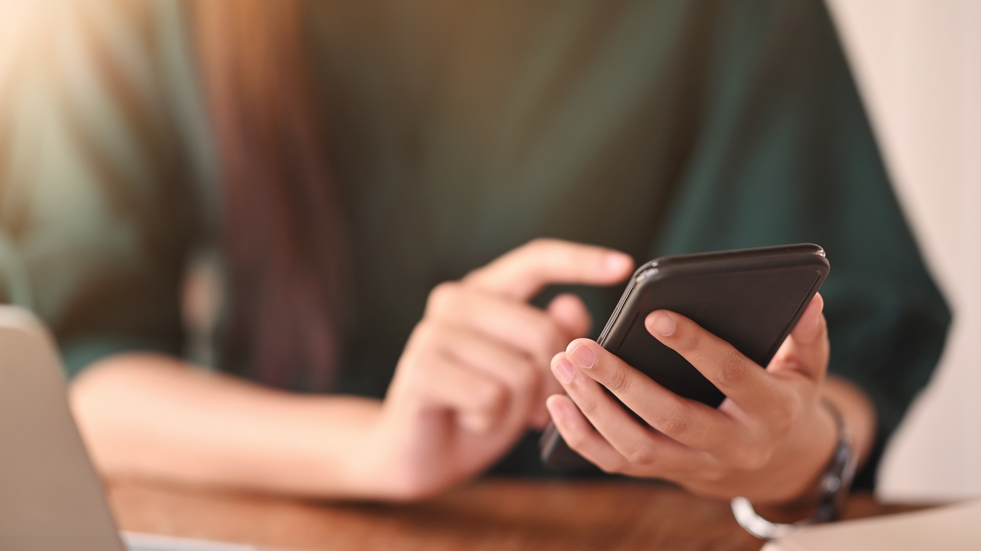 Person tippt auf Smartphone am Arbeitsplatz | E Liquid