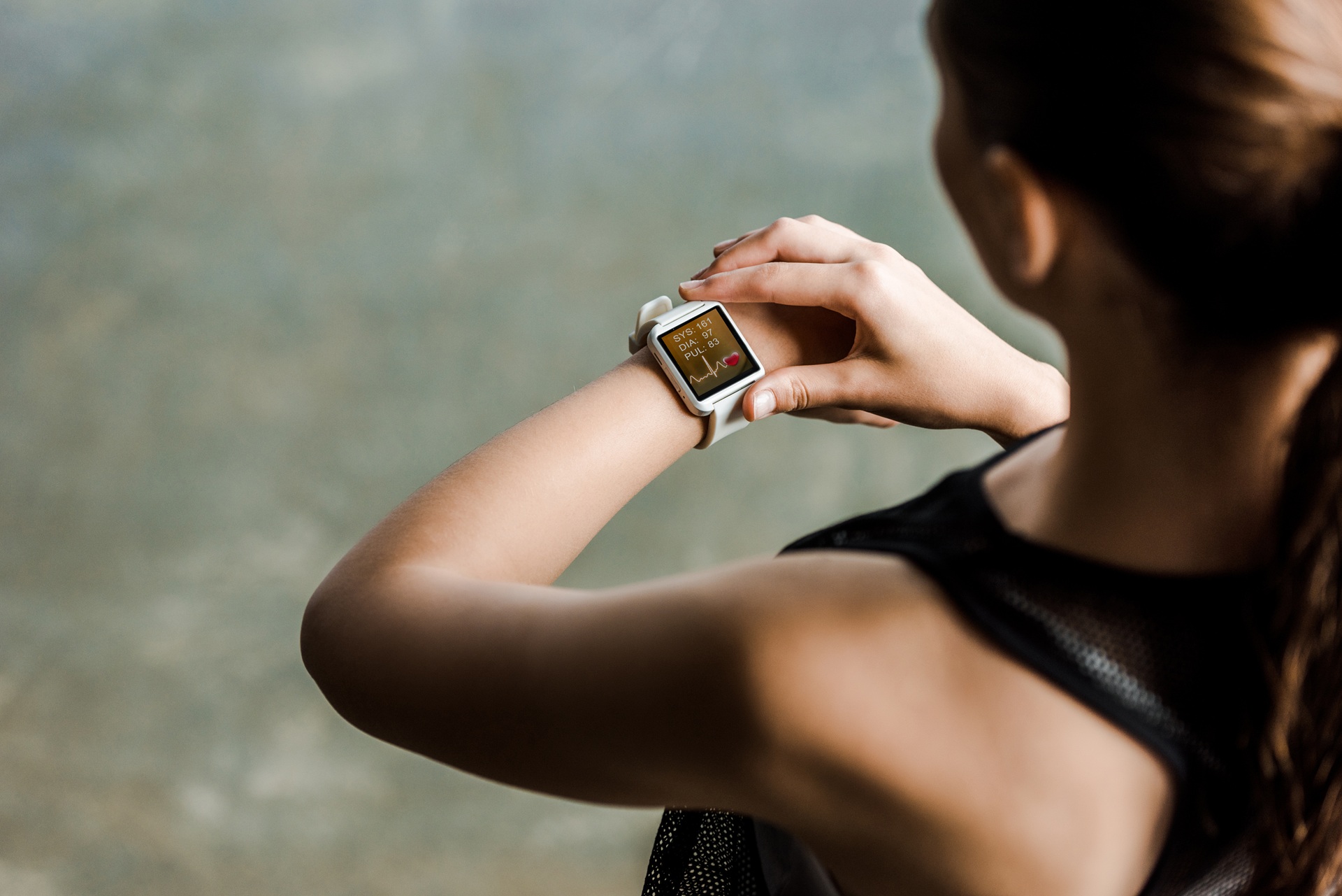 Frau prüft Fitnessdaten auf Smartwatch | E Liquid