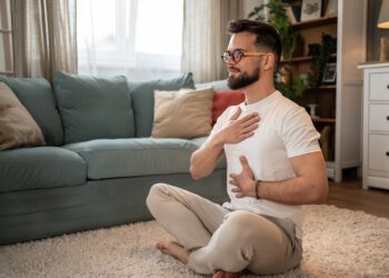 Mann bei Atemübung zu Hause auf Teppich | Escort Düsseldorf