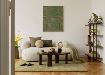Modernes Interieur mit grafischen Wandkunst-Mockups, skulpturalen Dekorationen, Bouclé-Sofa und grünen Akzenten. Eine kuratierte Mischung aus Texturen und Formen.