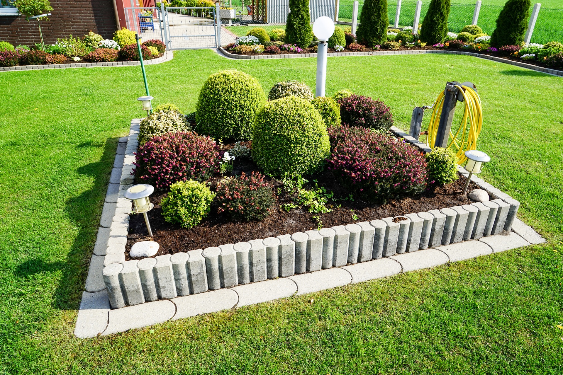 Gepflegter Gartenbereich mit Strauchbeet und Rasen | Hochbeet kaufen